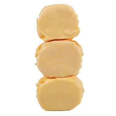 Close-up of three unwrapped Brigham City Peach Taffy candies stacked to show soft, whipped texture and creamy peach color